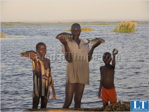 A Sinazongwe fisherman with his children on Lake Kariba A Sinazongwe fisherman with his children on Lake Kariba