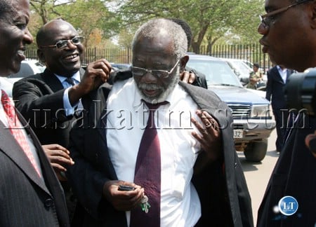 Newly appointed Labour, Sports, Youth and Gender Minister Fackson Shamenda is helped to wear his jacket properly on his arrival at State House
